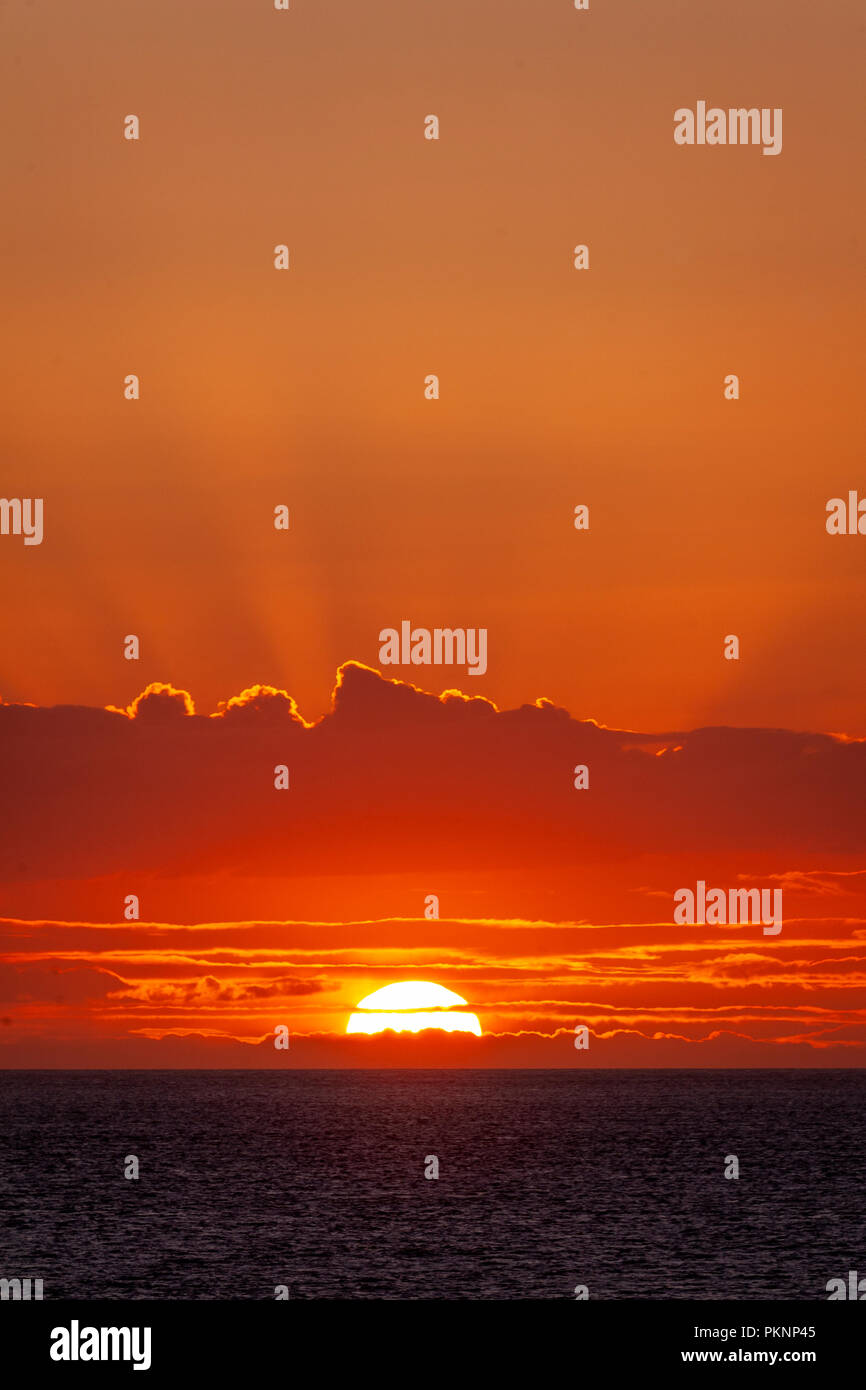Vivid sunset over the sea with clouds Stock Photo
