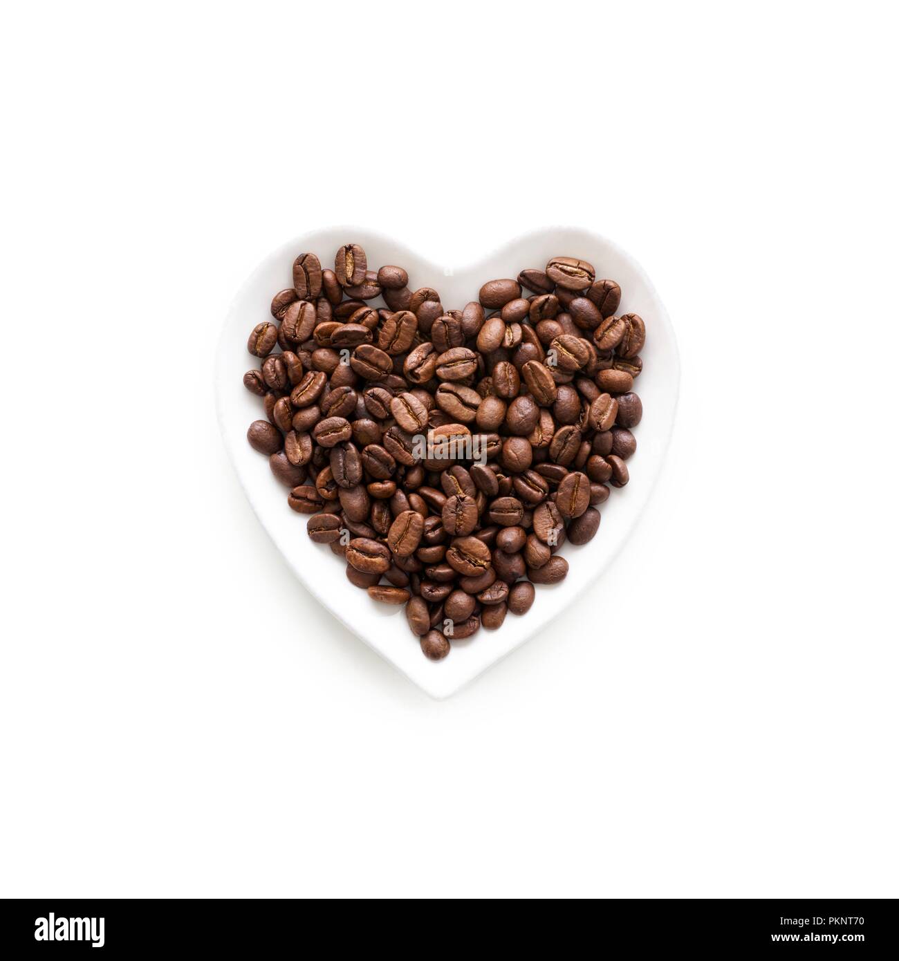 Coffee beans in a heart shape bowl. Stock Photo
