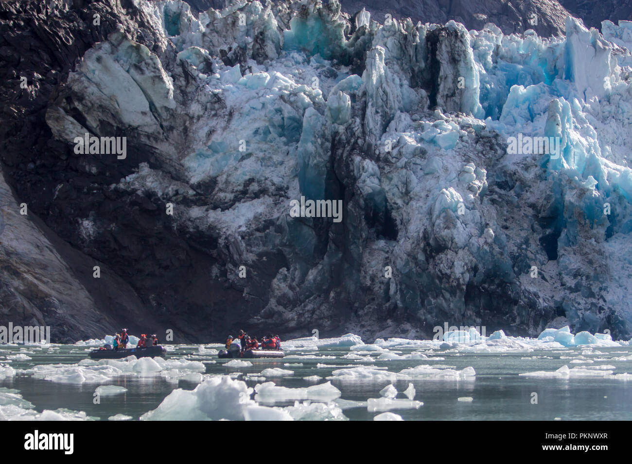 Ecotourists visit a tidewater glacier in southeast Alaska and witness a massive calving event at the south Sawyer Glacier in Tracy Arm Stock Photo