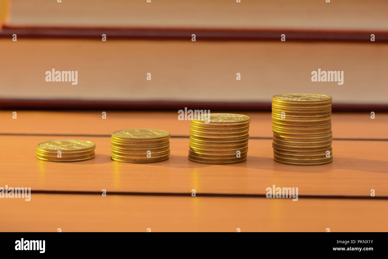 Coins pile making progress on wooden table, Money concept. Stock Photo