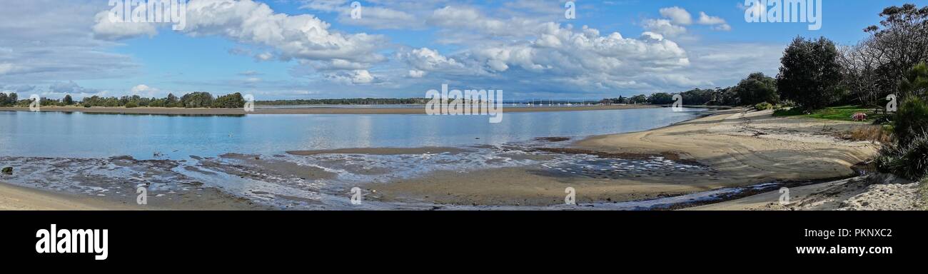 Panoramic landscape river beach scene with a cloud filled sky. Stock Photo