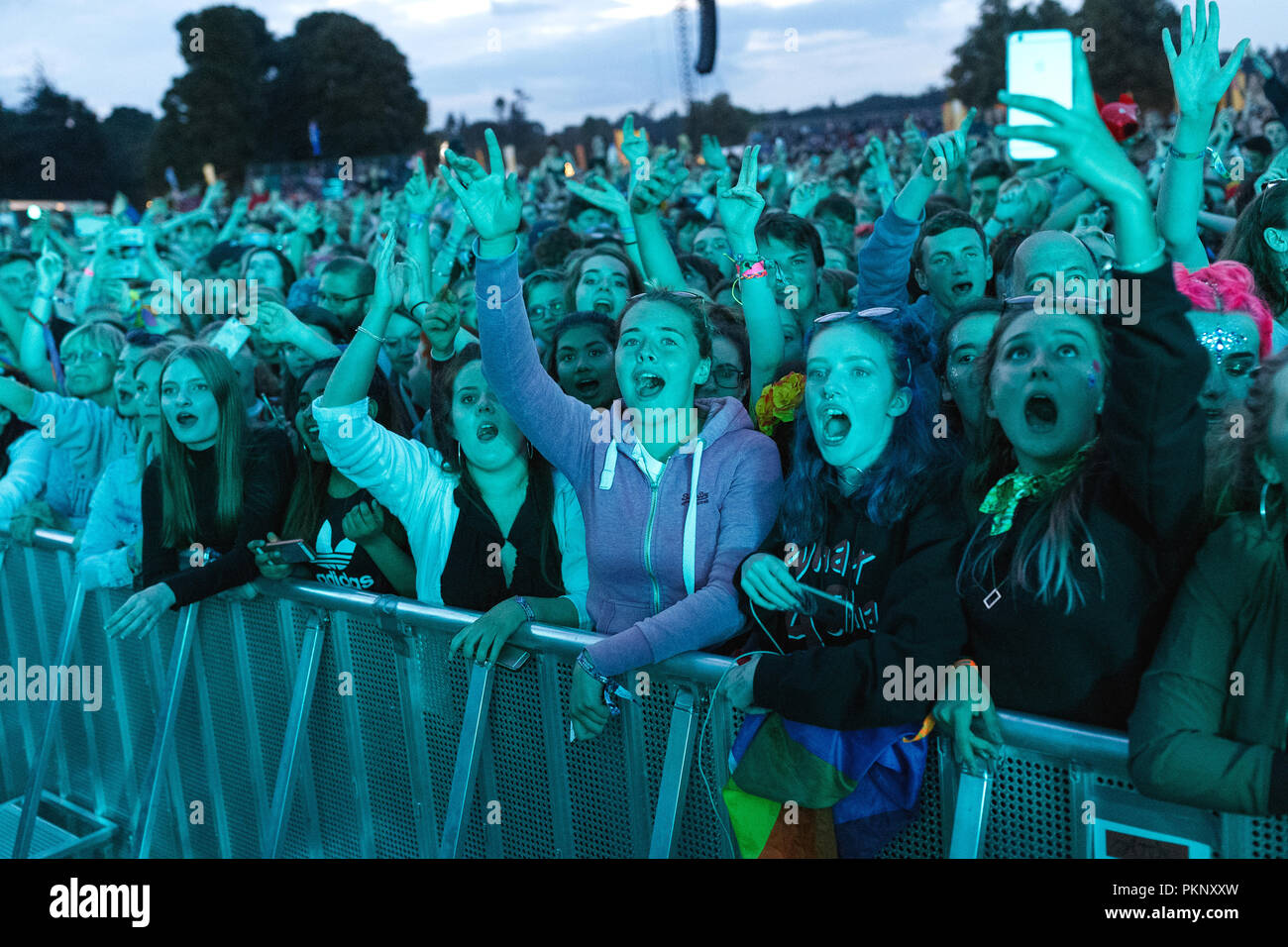 Young music fans at an outdoor music festival in the United Kingdom. Teenagers at a music festival, music festival crowd, teenage girls cheering, starstruck music fans. The festival pictured is Latitude Festival. Stock Photo