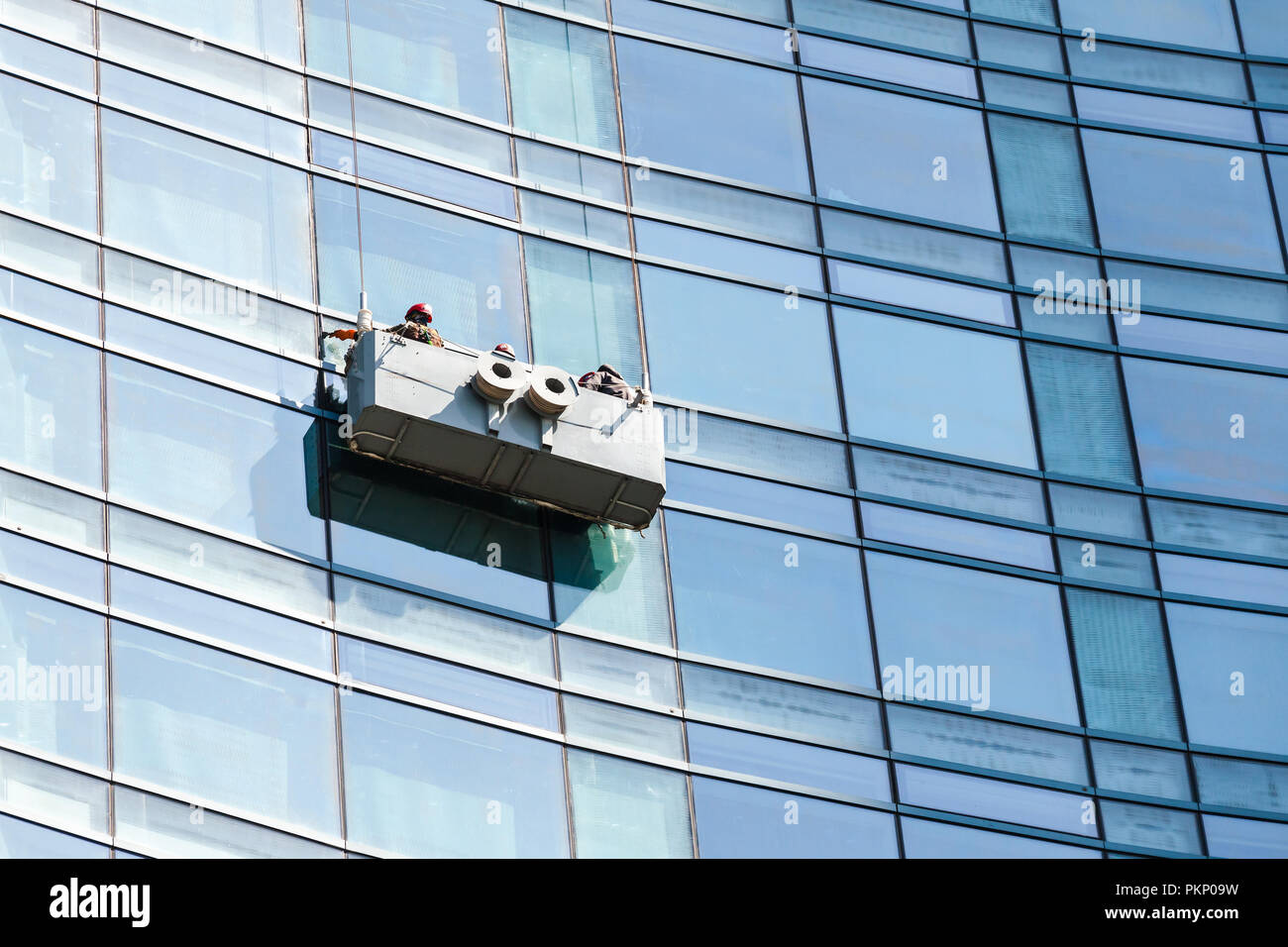 Office building maintenance, glass facade cleaning with cradle Stock Photo