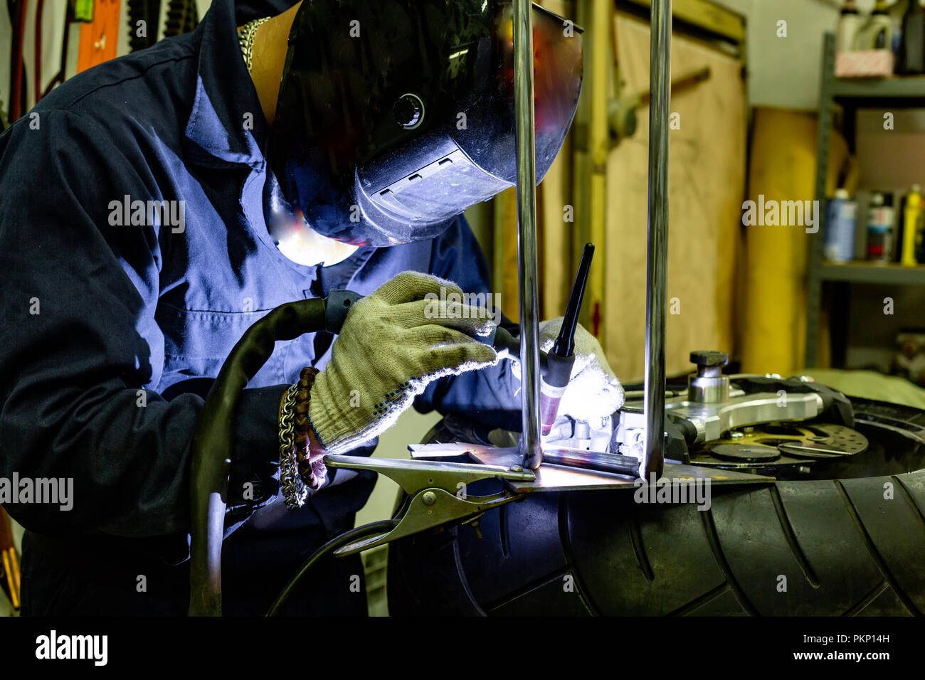 Professional car mechanic working in auto repair service on argon gas cutting machine Stock