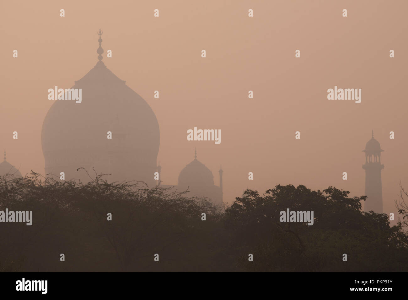Romantic Taj Mahal the wonder of the world and the pride of India with its main dome & minaret in early morning winter warm light and haze  Agra India Stock Photo