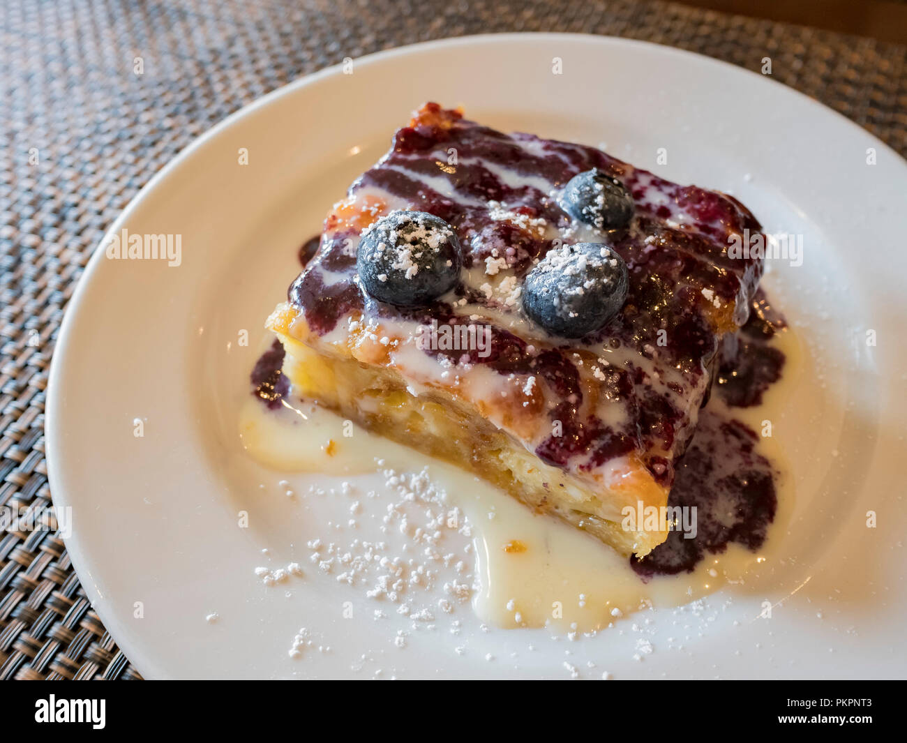 Close up shot of blueberry bread pudding with condensed milk, ate ...