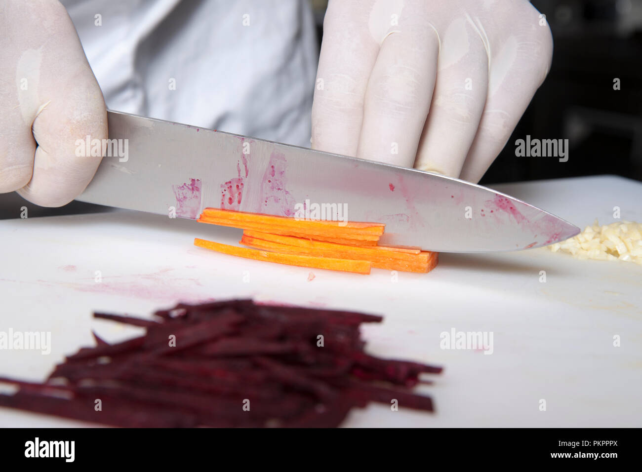 the cook cuts carrots into slices in the restaurant kitchen Stock Photo