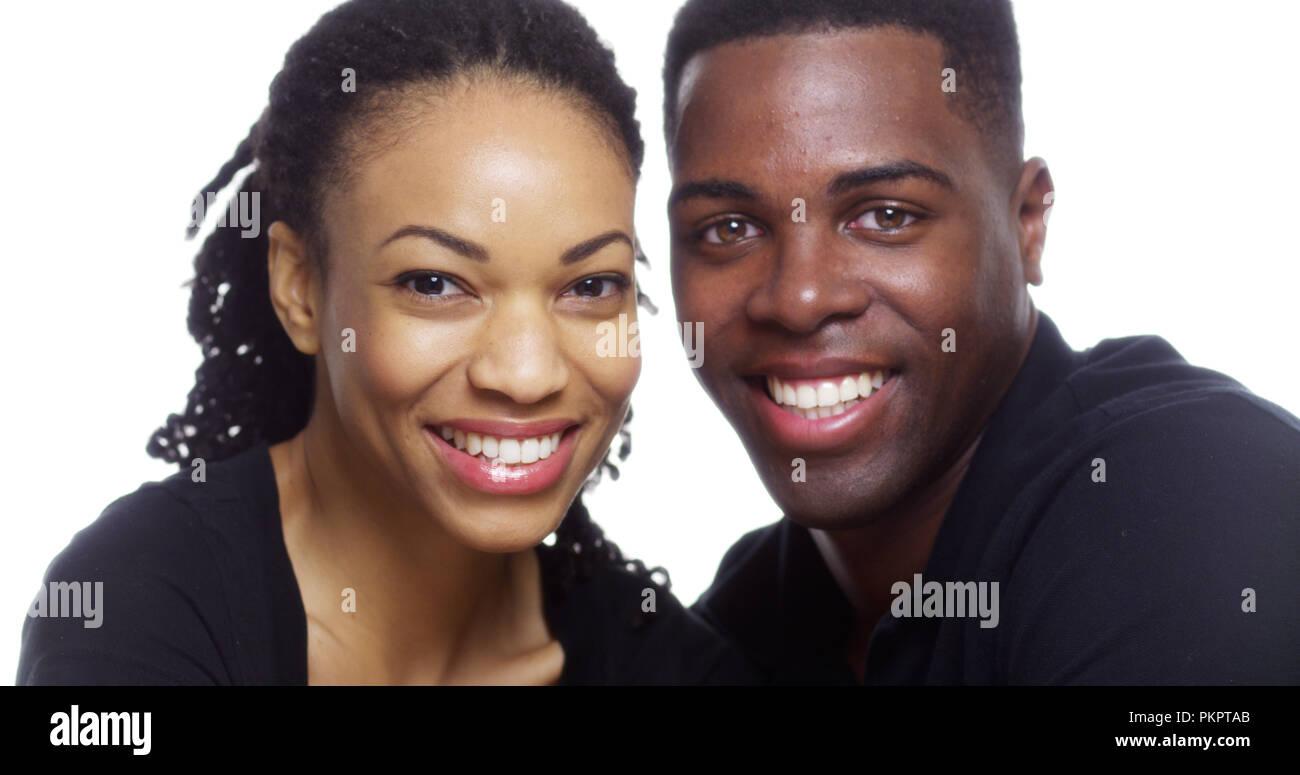 Happy smiling young black couple looking at camera on white background ...