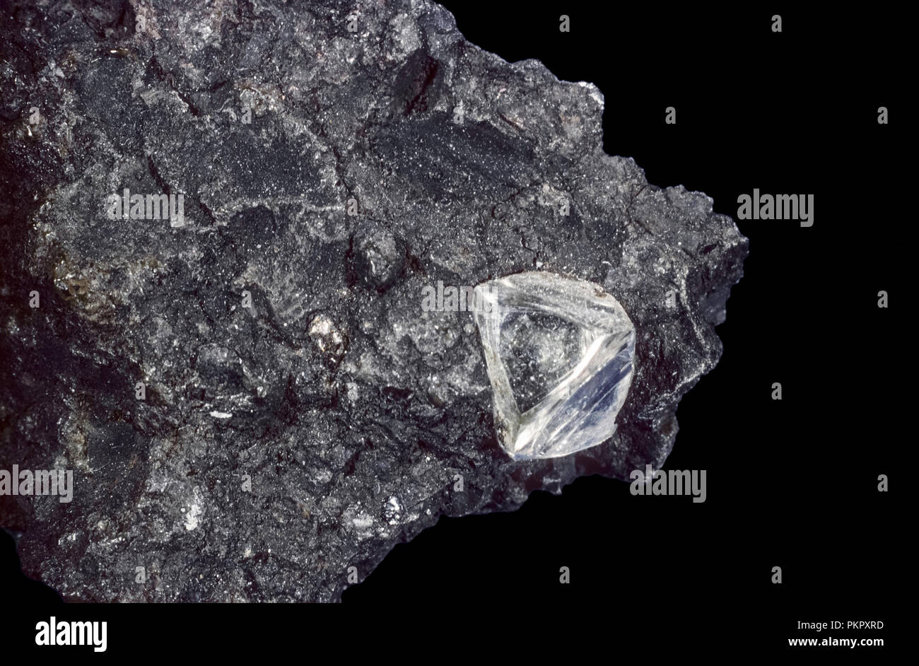 Diamond in Kimberlite (Peridotite) on black background, Kimberly, South Africa Stock Photo