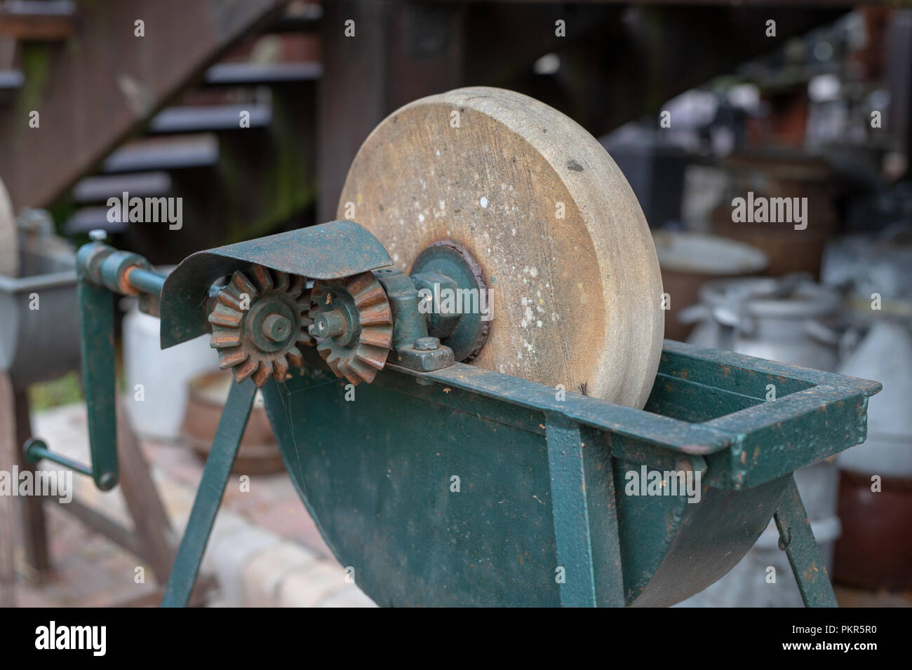 Sharpening knife on old grindstone wheel Stock Photo - Alamy