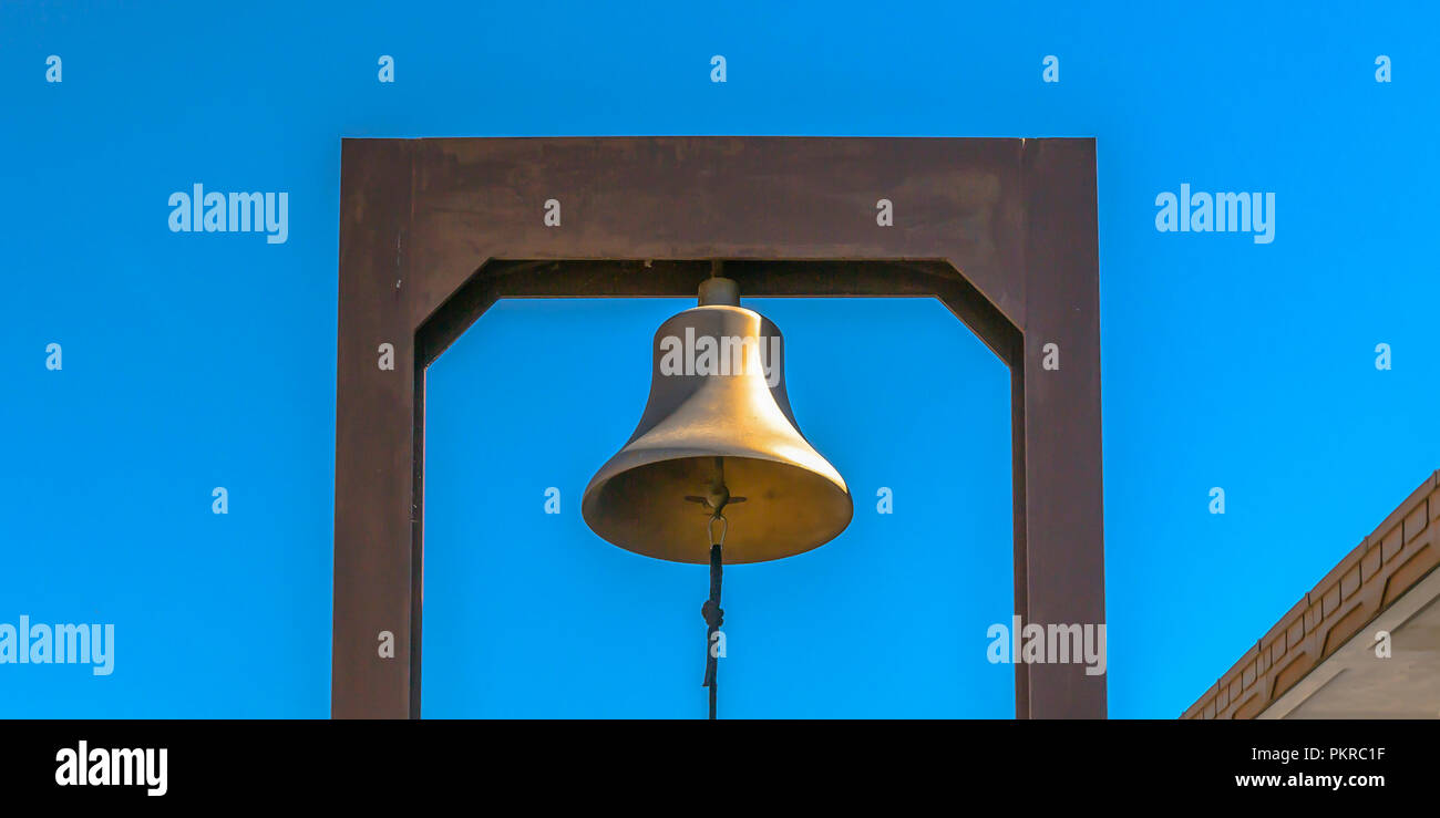 Bell with blue rope attached to a rectangular yoke Stock Photo