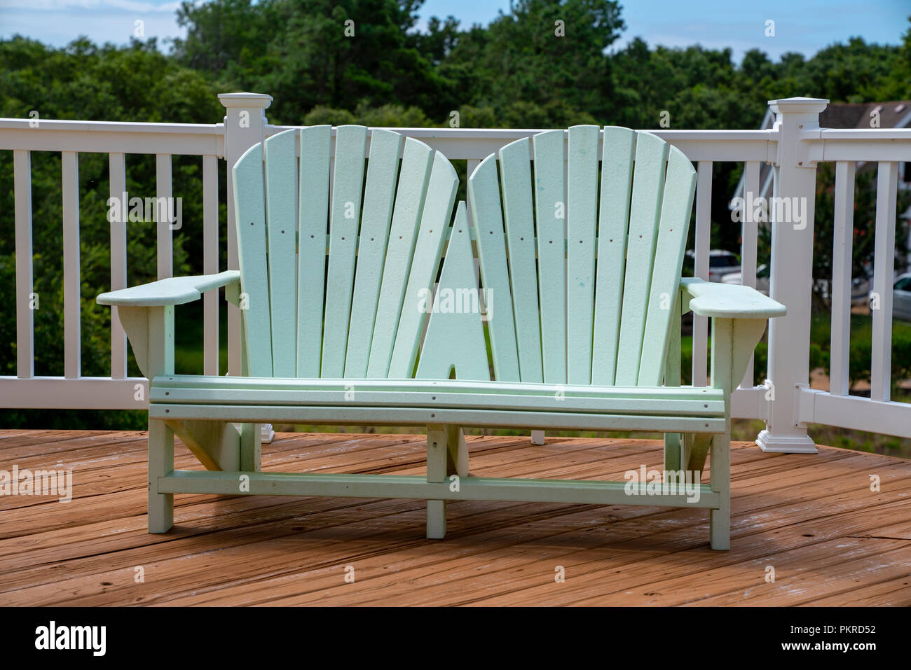 Adirondack Chairs sit on a deck of a vacation home in the Corolla