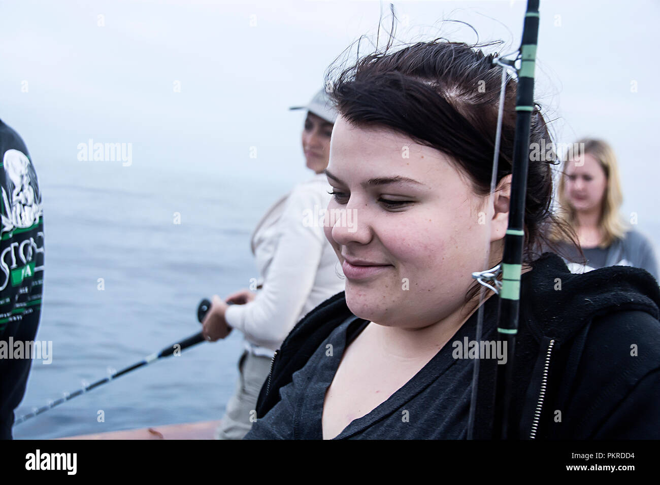 Young woman holding fishing pole hi-res stock photography and images - Alamy