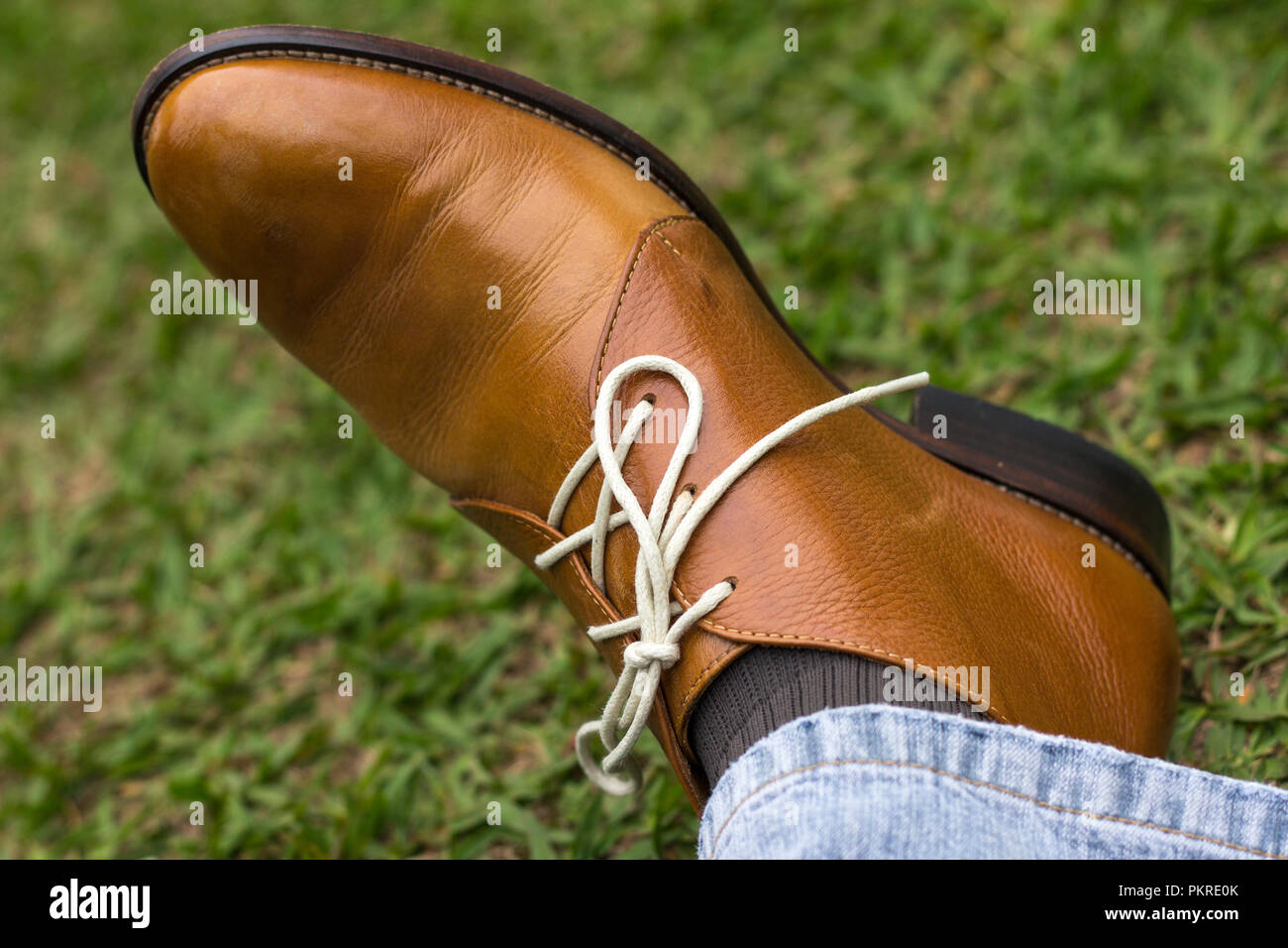 Brown boot with white laces and jeans Stock Photo Alamy