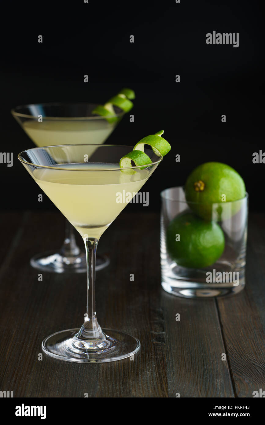 Two daiquiris served in cocktail glasses, garnished with lime zest