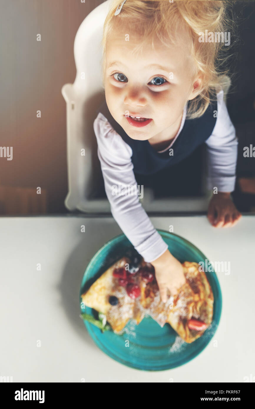 2 years old child eating pancakes. top view Stock Photo