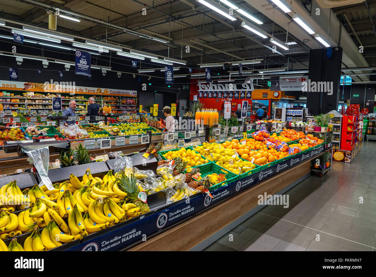 Fruit aisle in French supermarket with bananas, oranges Stock Photo