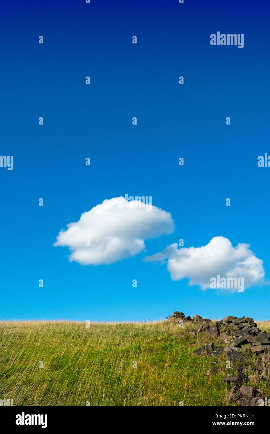 Blue sky and white ,fluffy clouds above grassy field, Peak District National Park Stock Photo