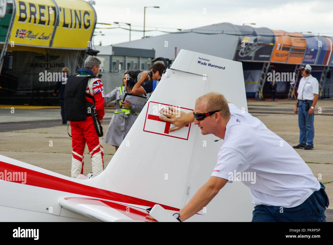 Engineer Wade Hammond pushing Paul Bonhomme plane whilst Paul is interviewed by TV crew. Red Bull Air Race Stock Photo