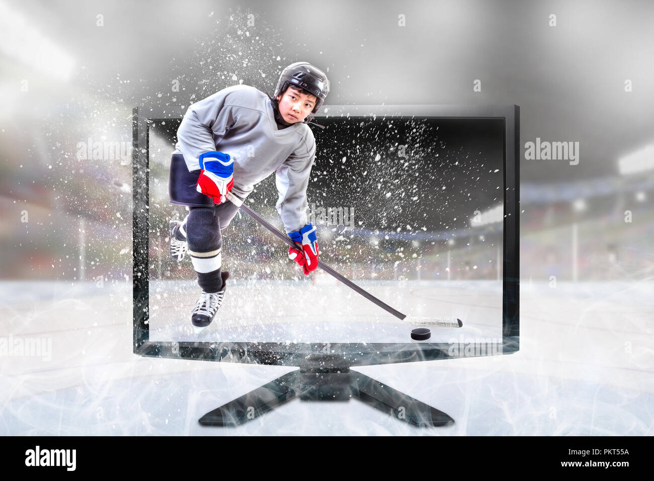 Junior ice hockey player in competitive sports gear standing inside brightly lit outdoor stadium on TV monitor