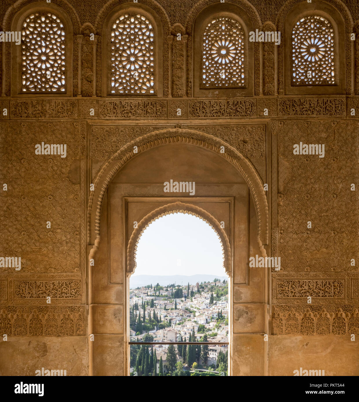 View of the Albayzin district of Granada, Spain, from an arched window in the Alhambra palace near sunset at Granada, Spain, Europe on a bright sunny  Stock Photo