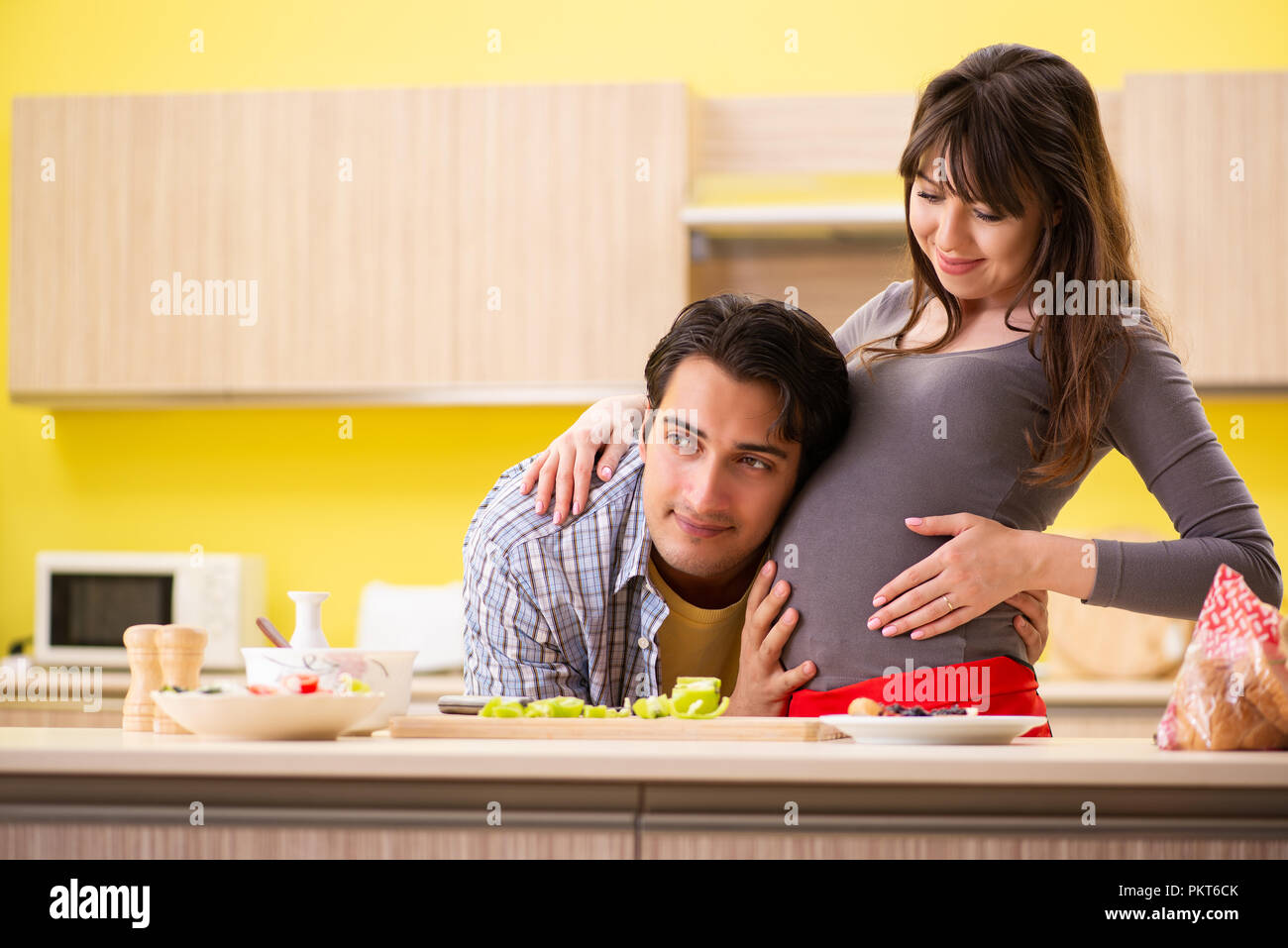 Man and pregnant woman preparing salad in kitchen Stock Photo - Alamy