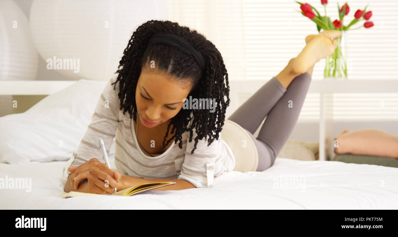 Happy black woman writing in journal Stock Photo - Alamy