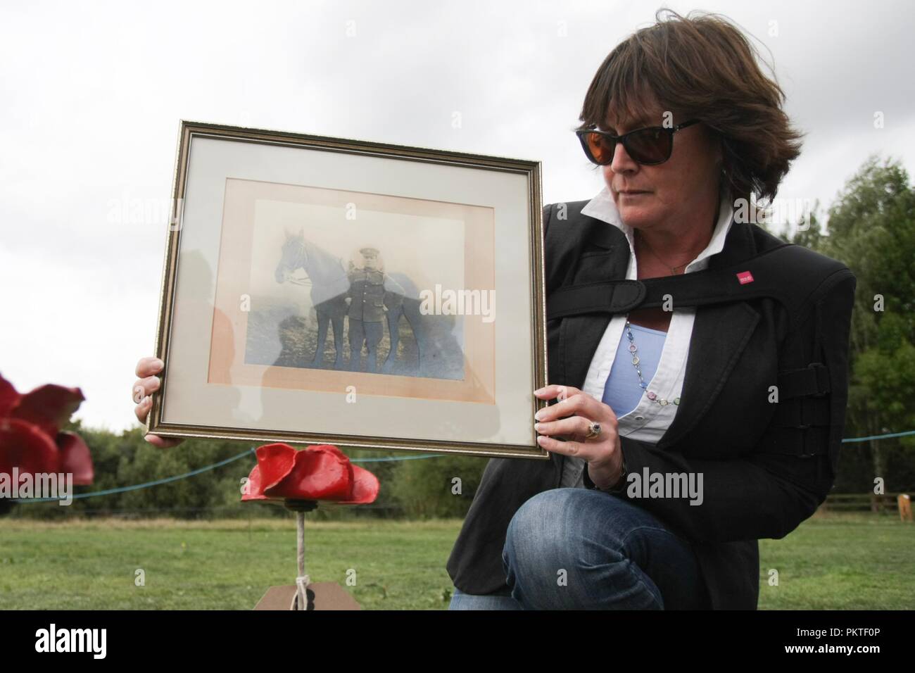 Worcester, Worcestershire, UK. 15th September 2018. Deborah Webb displays a photograph of her great grandfather William Henry Phipps who died at sea in 1915, and a poppy she has from Blood Swept Land and Seas of Red by artist Paul Cummins, at the Drumhead Service at Gheluvelt Park, Worcester. Peter Lopeman/Alamy Live News Stock Photo