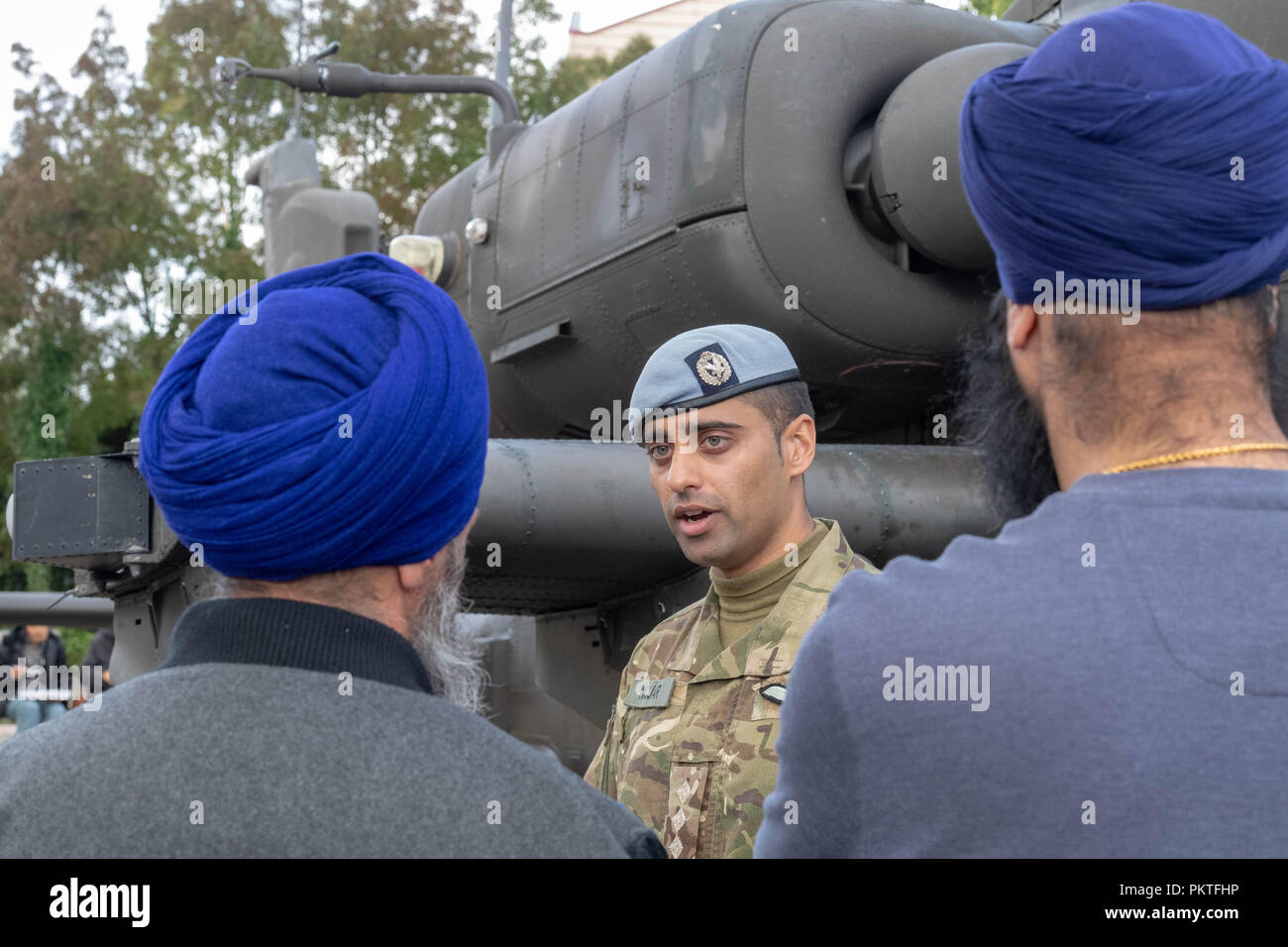 London 15th September 2018 UK Army open day to mark annual Saragarhi Commemorations This celebrates an epic battle where 21 Sikh soldiers took a last stand against 10,000 enemy tribesmen in 1897   An army air corp apache attack helicopter pilot talks to some sikh  visitors next to his helicopter Credit Ian Davidson/Alamy Live News Stock Photo
