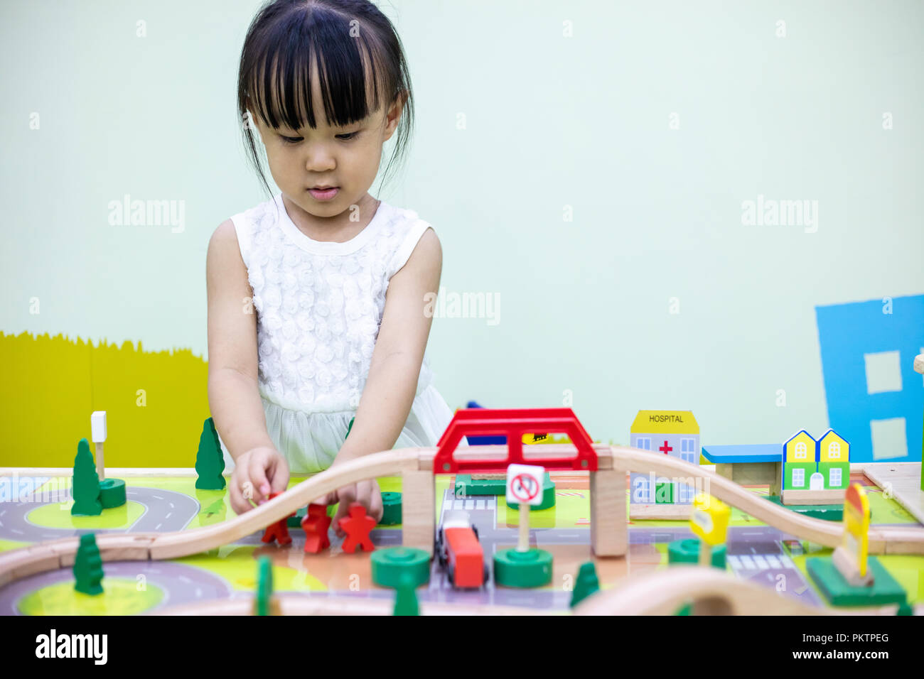 Asian Chinese little girl playing wooden toy train at indoor playground ...