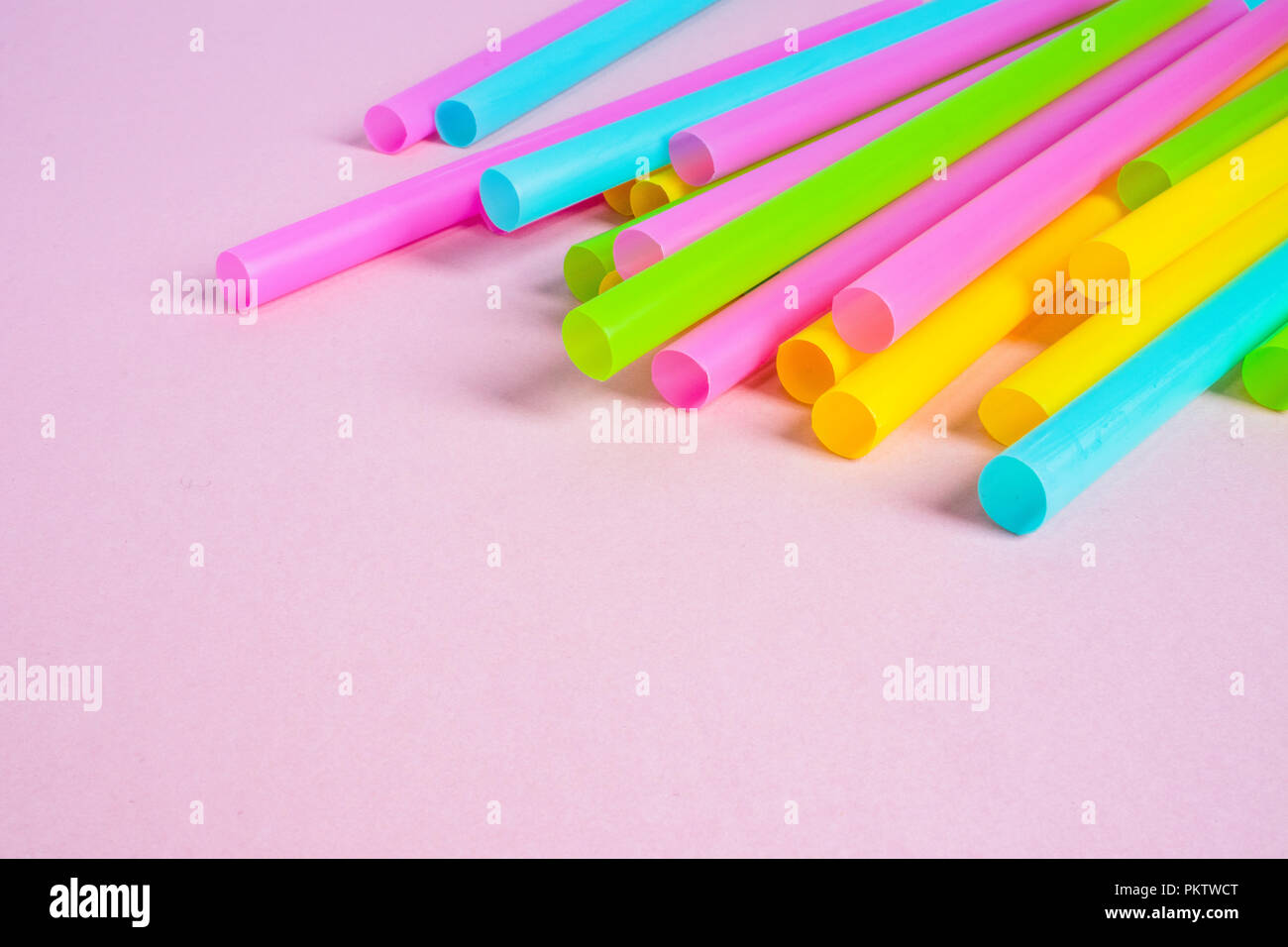 Multicoloured Plastic Drinking Straws on Pink Background Stock Photo