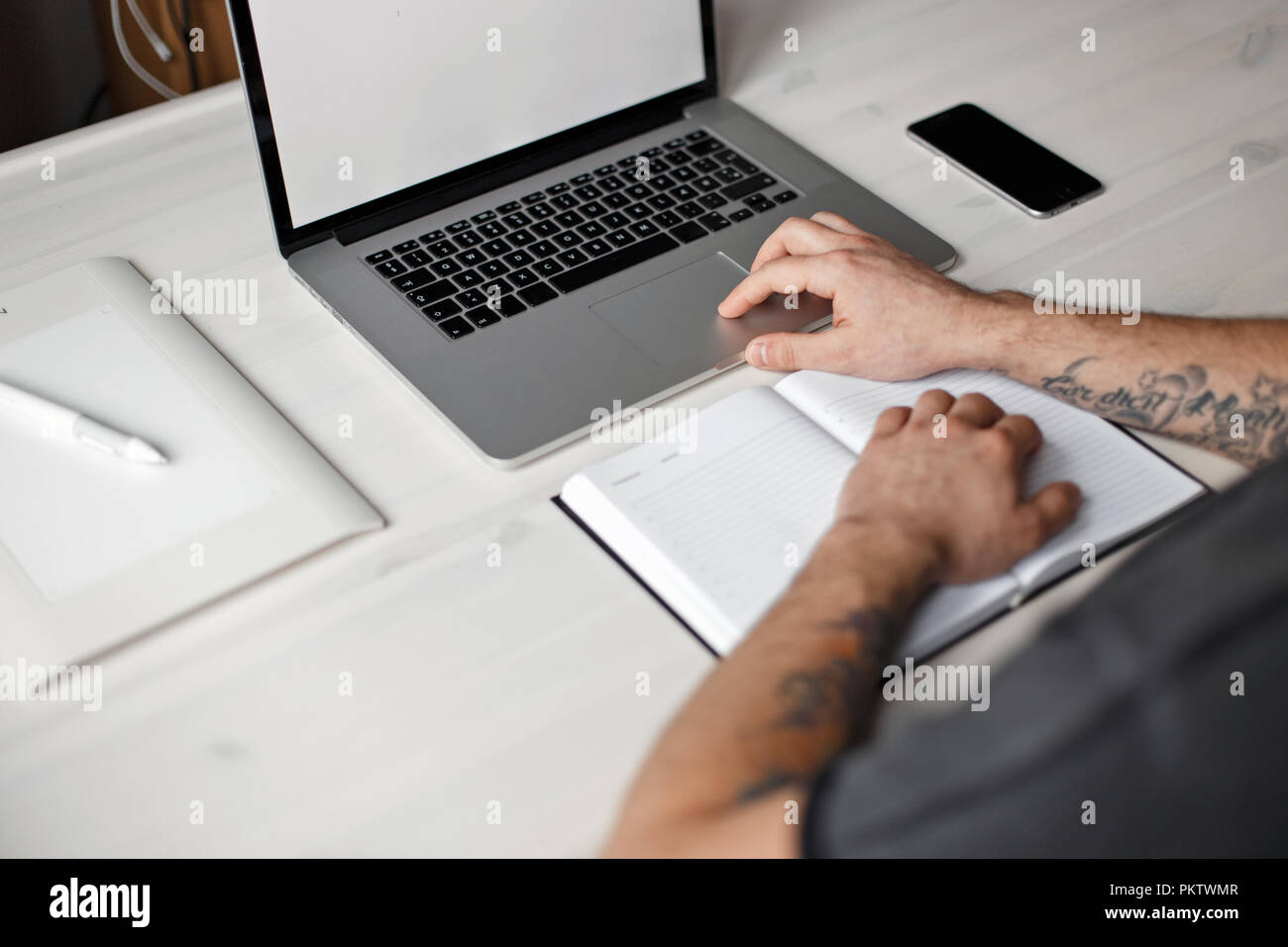 Desk with laptop, notepad, phone, graphic tablet Stock Photo - Alamy