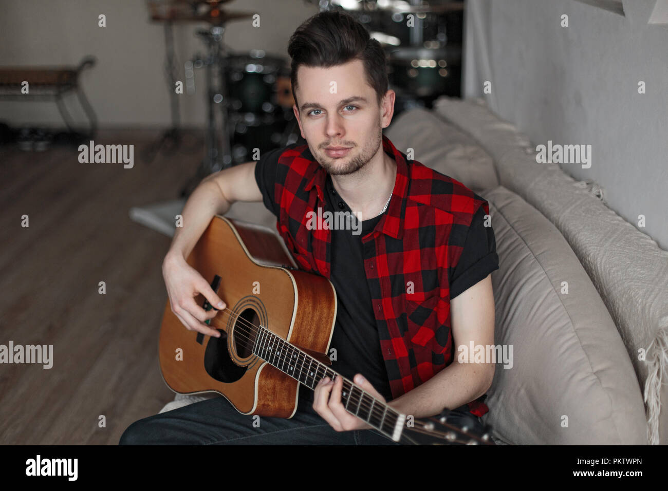 Handsome young man playing the guitar Stock Photo