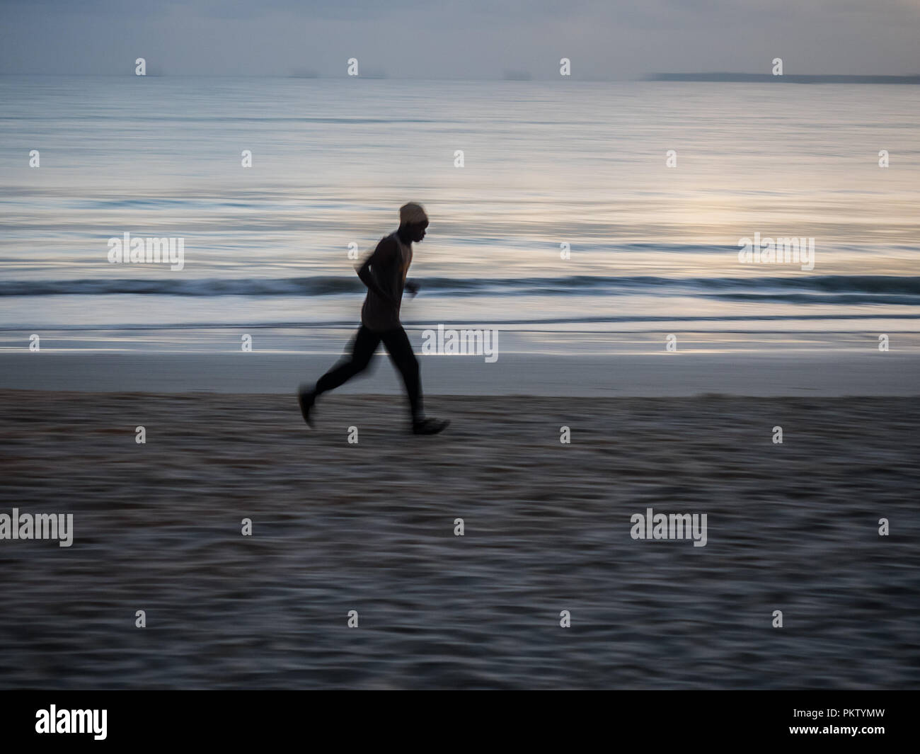 Local athlete doing morning exercise at dawn on the beach at Dar es Salaam, Tanzania Stock Photo