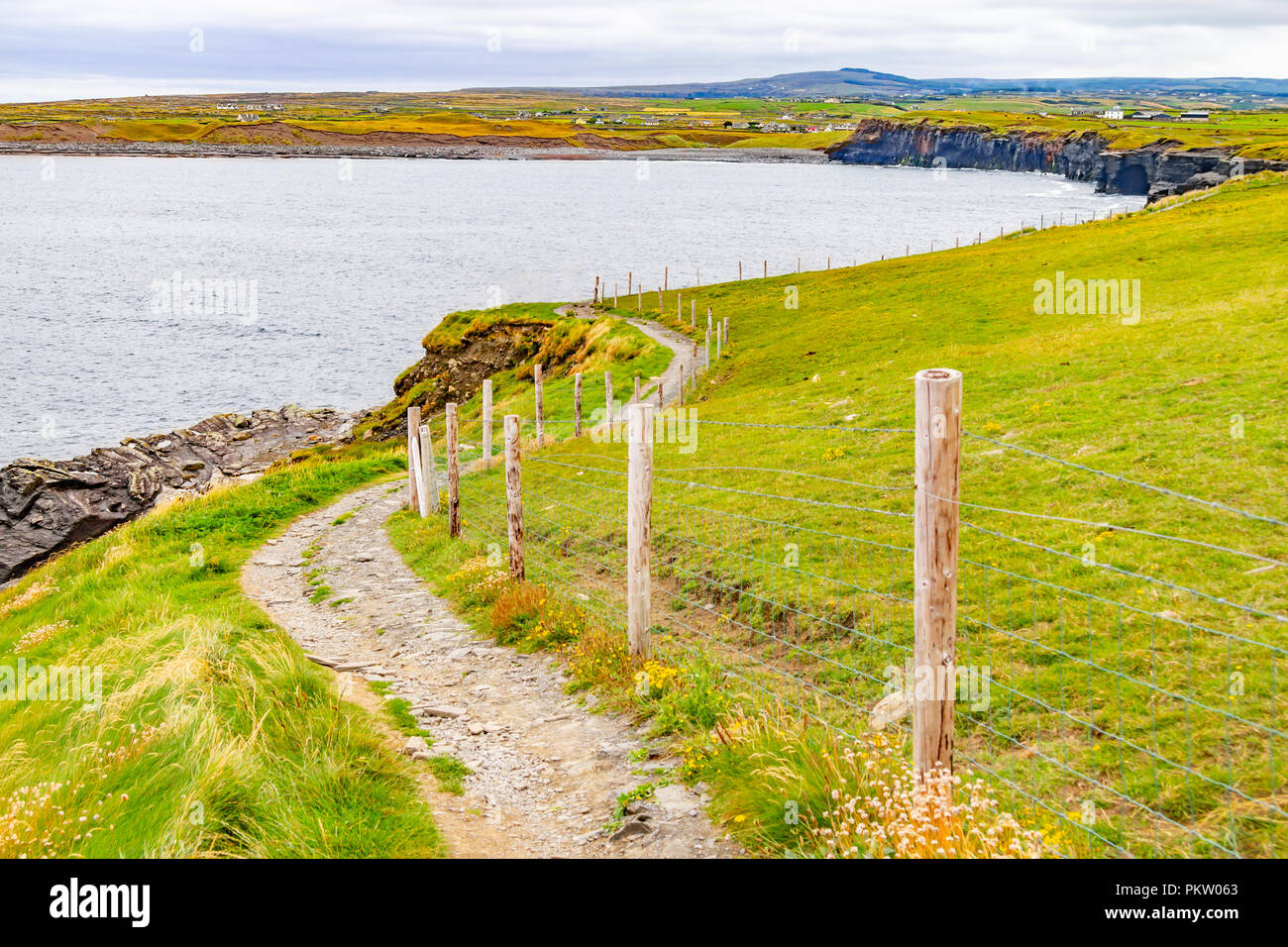 Cliffs of Moher trail with Doolin village and farm fields in background, Clare, Ireland Stock Photo