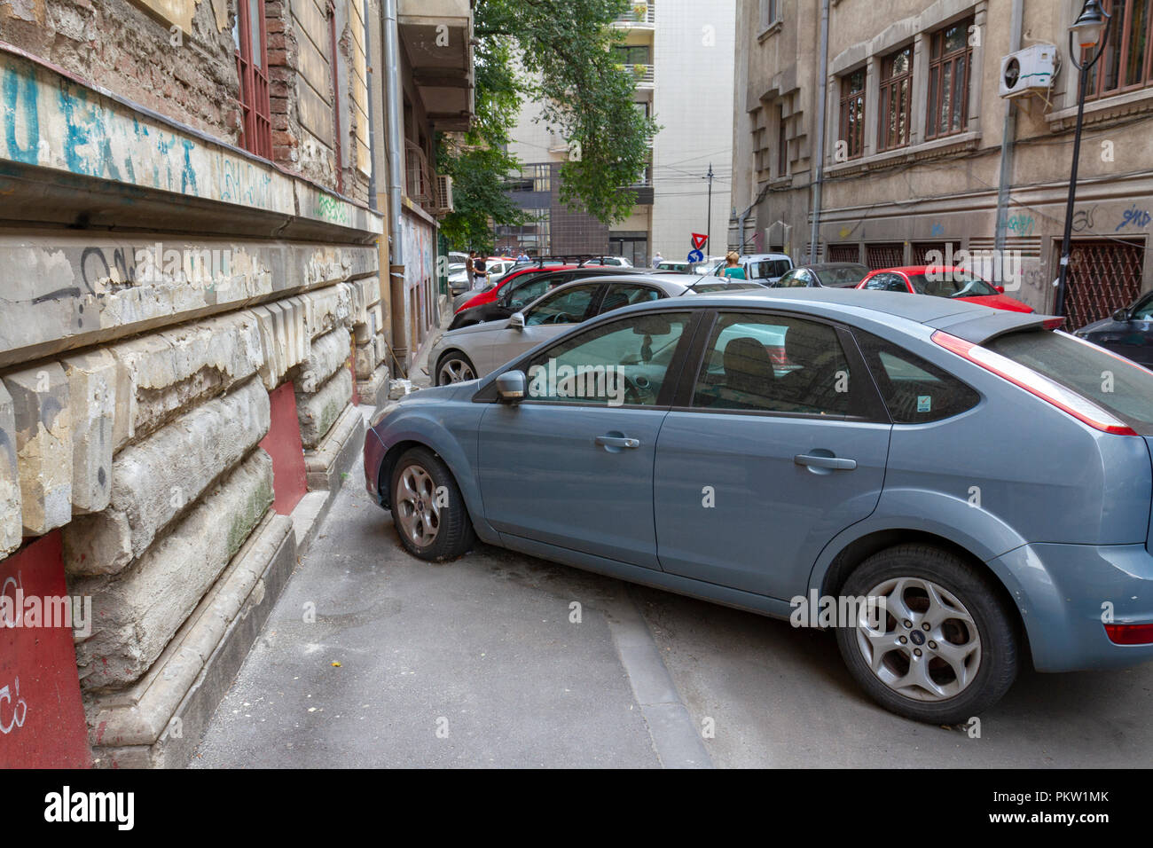 Typical pavement car parking in central Bucharest, Romania.  Parking on pavements, in driving lanes & blocking others is normal in Bucharest. Stock Photo