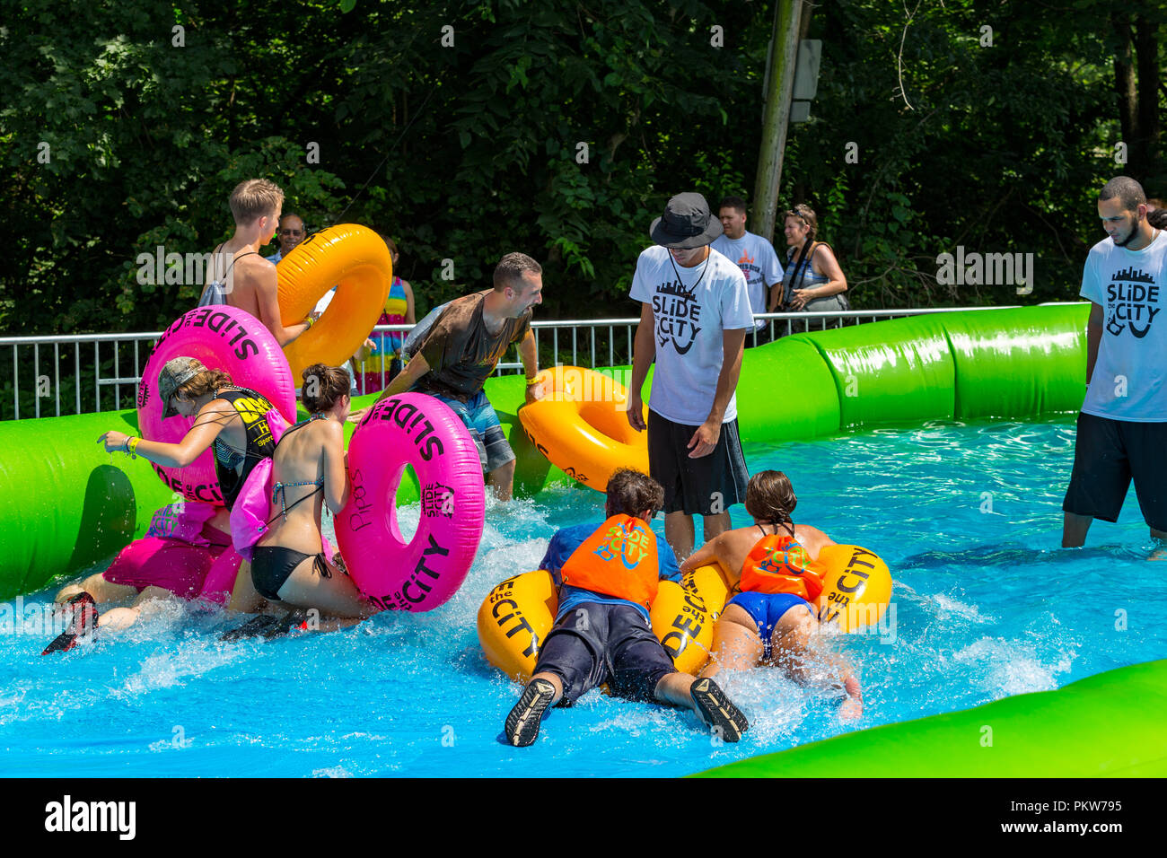 Lancaster, PA, USA - July 19, 2015: Riding a circular raft at the Slide the City event features a giant water Slip 'N Slide that is a 1,000-foot long. Stock Photo