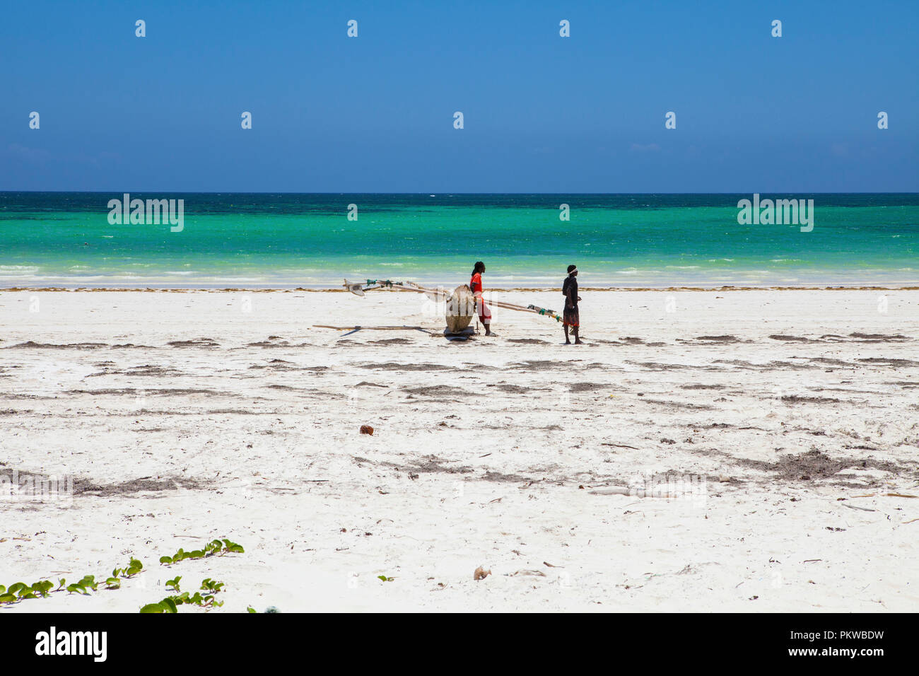 GALU - KINONDO, KENYA - FEBRUARY 24, 2018: young kenyan man walking on the Galu - Kinondo beach in Kenya, coast, at low tide. Stock Photo