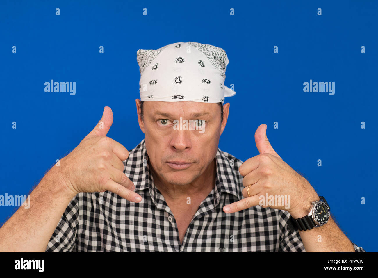 Male plaid shirt and white headband gesturing Stock Photo