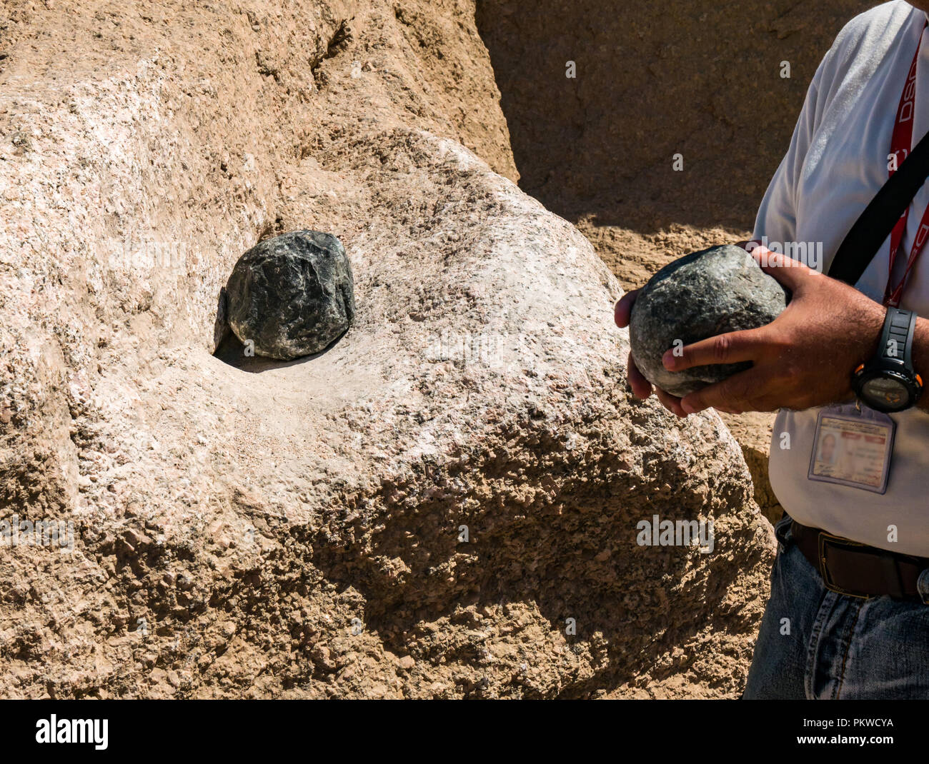 Guide showing grinding of granite stones at ancient Egyptian quarry, Aswan, Egypt, Africa Stock Photo