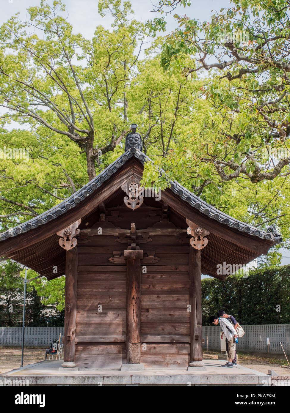 Visitors bowing at temple gate before entering, Motoyamaji, Temple 70 of 88 Temple Shikoku Pilgrimage, Kagawa, Japan Stock Photo