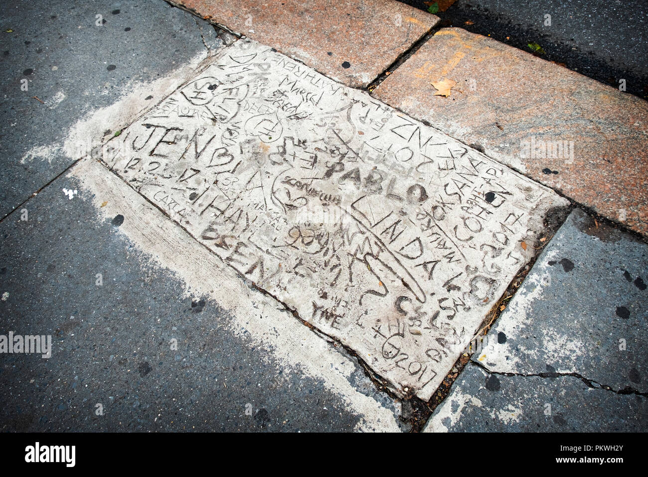An unusual slab of cement on 42nd Street near the library, where passersby wrote their initials and messages. In Midtown Manhattan, New York City. Stock Photo