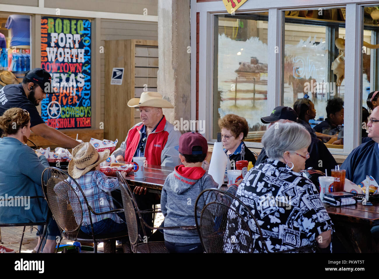 Staycation idea. Texan family enjoys meal at outdoor table at Fort Worth Stock Yards. East Exchange Avenue, Fort Worth, Texas. horizontal Stock Photo