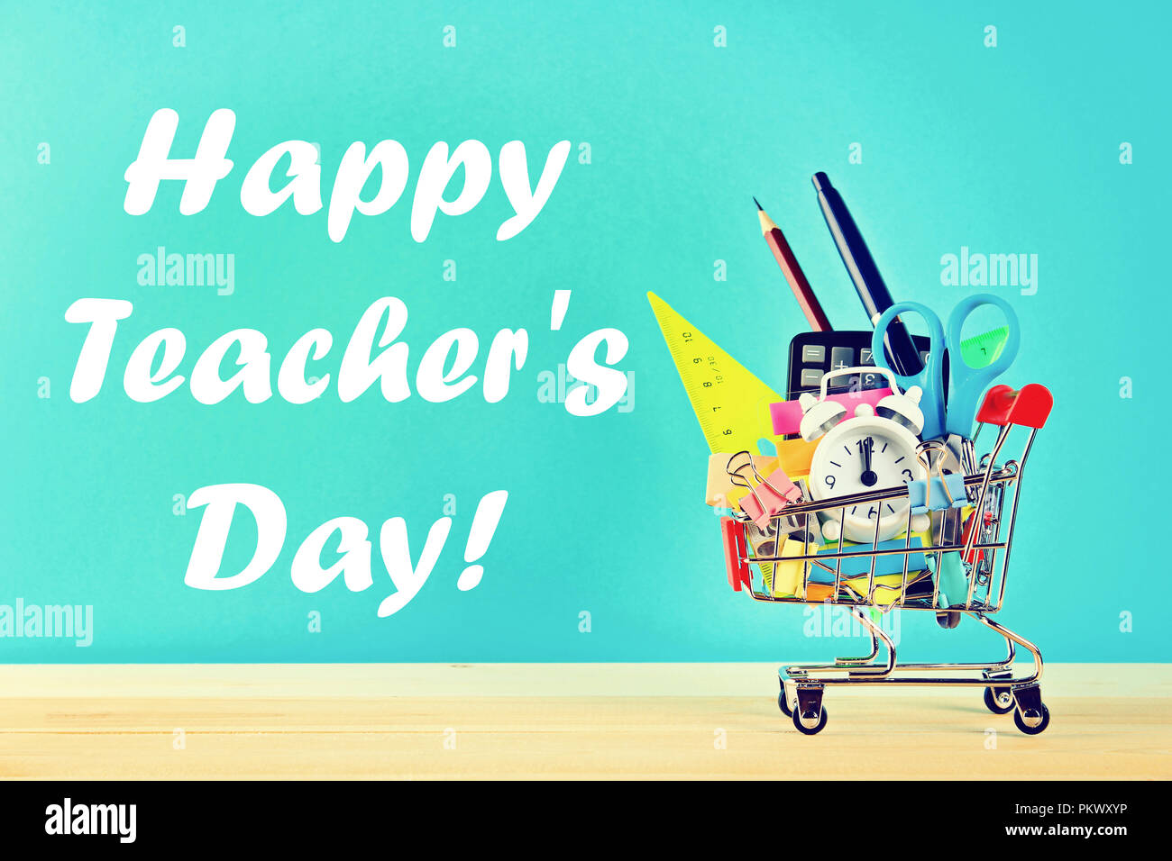 Happy Teachers Day. Shopping cart with stationery objects. Office and