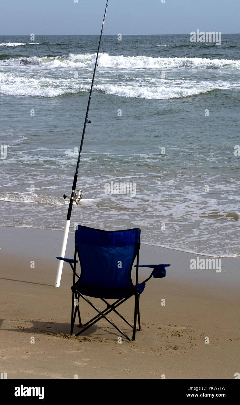 Image of ocean and portable chair with surf fishing rod in sand