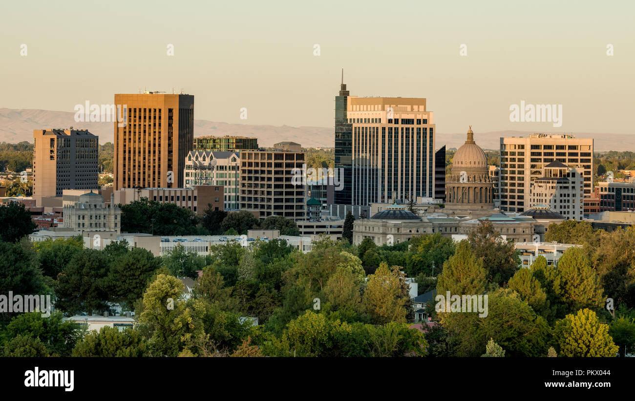 First warm light of the day illuminates the sides of the buildings making up the skyline of Boise Idaho Stock Photo