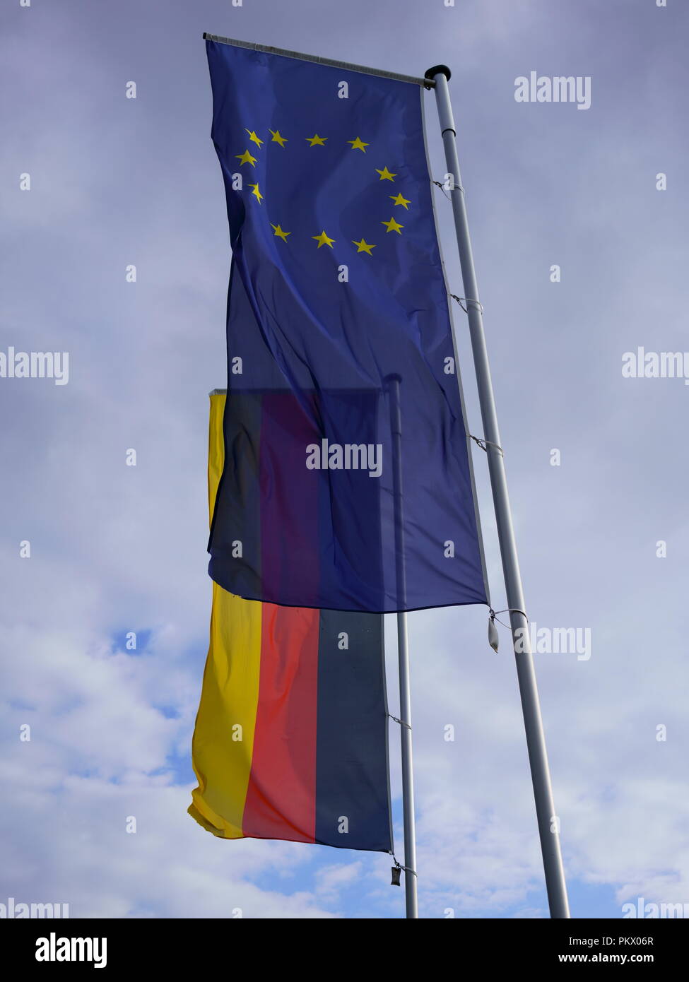 Flag of Europe along with flag of Germany. Transparent EU flag against German flag. Stock Photo