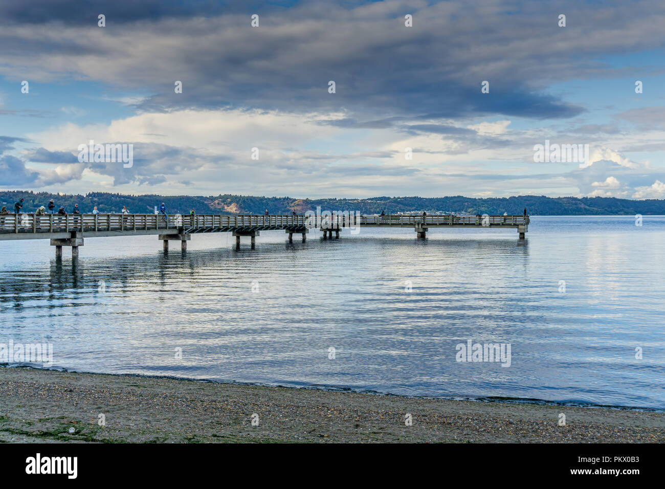 A view of the fishing pier at Dash Point, Washington. Clouds can be seen in the distance. Stock Photo