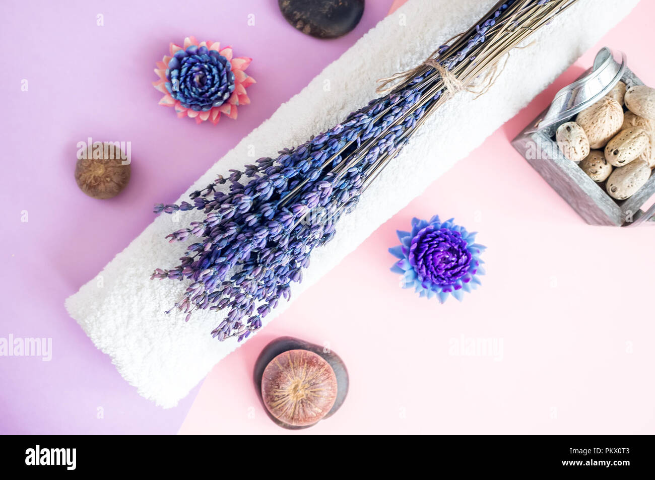 Beautiful soap in the form of flowers and towel with lavender flowers for Spa treatments on a two-tone background. Selective focus. Stock Photo