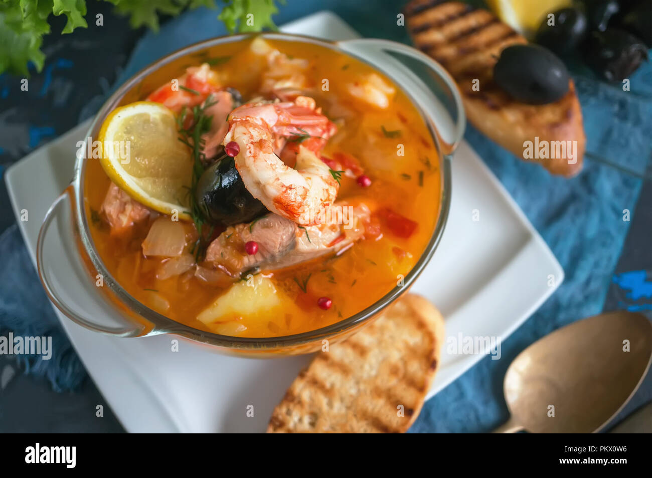 French fish soup Bouillabaisse with seafood, salmon fillet, shrimp ...